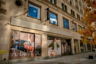 Storefront windows wrapped in Cozey graphics on a downtown street
