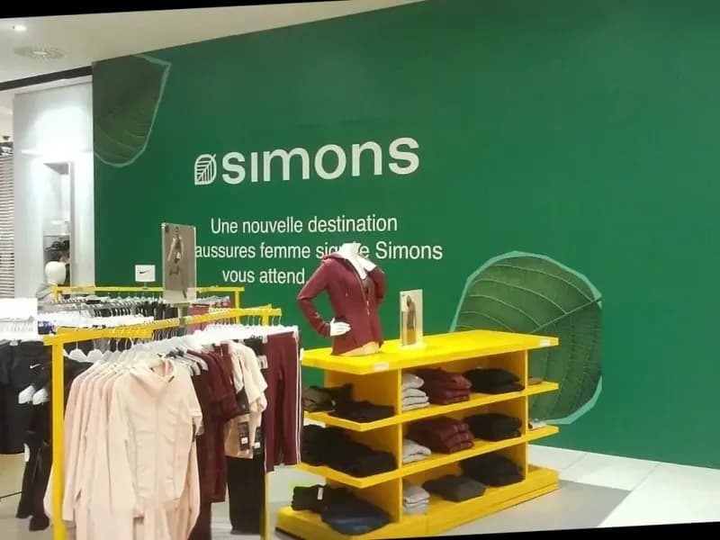 Green interior feature wall with Simons logo and leaf motifs in store