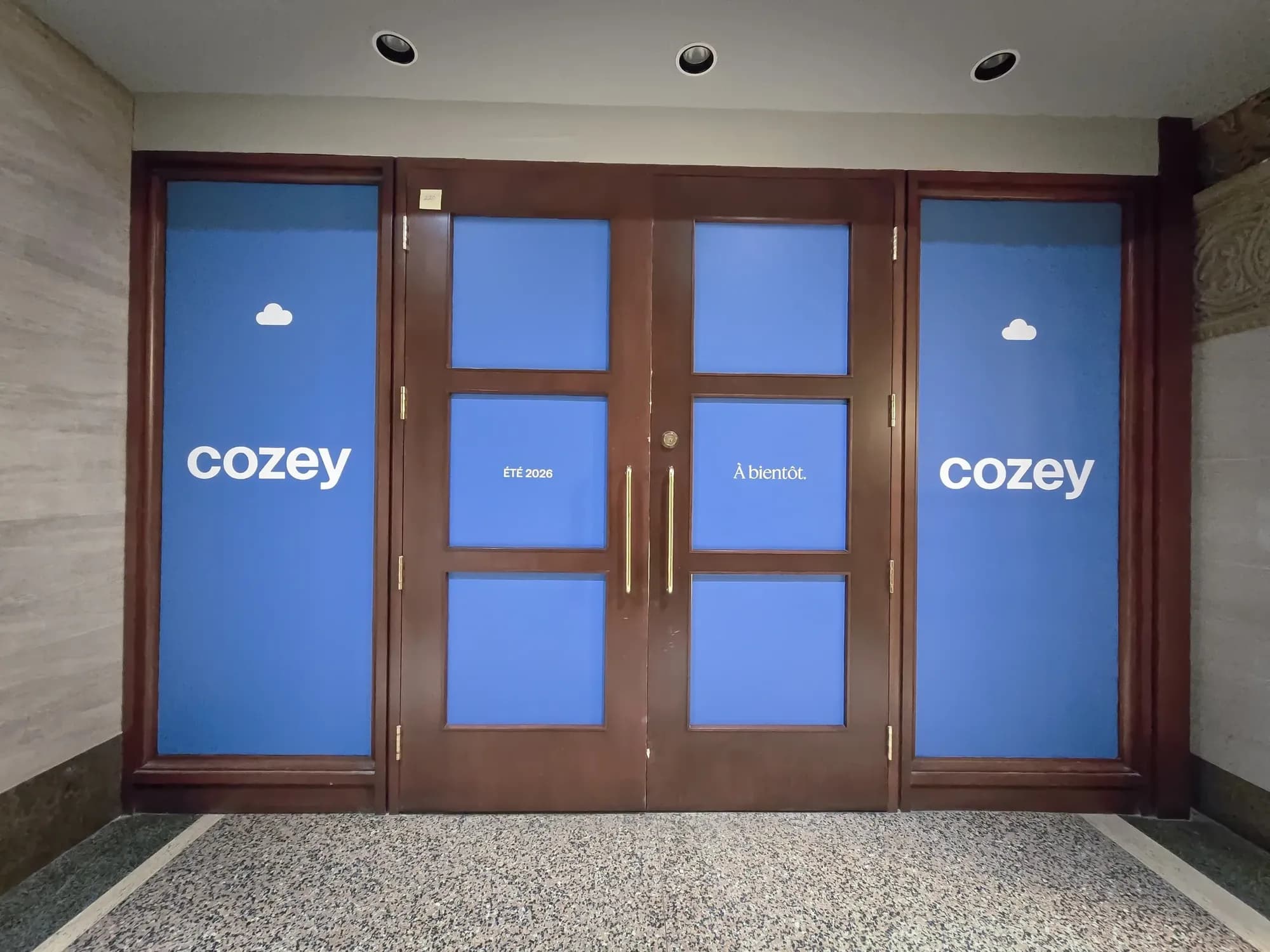 Entrance doors and glazing covered in blue Cozey “À bientôt” vinyl
